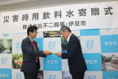 安藤代表取締役から目録を受け取る市長
