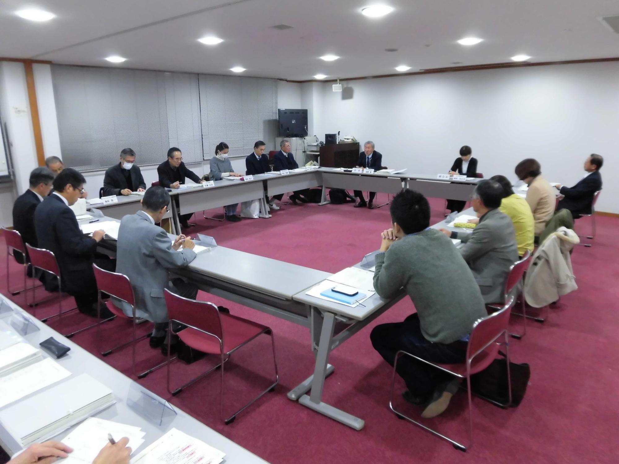 内側に向かい合うように長方形に並べられた席に座り、話し合いをしている第2回総合計画審議会の写真