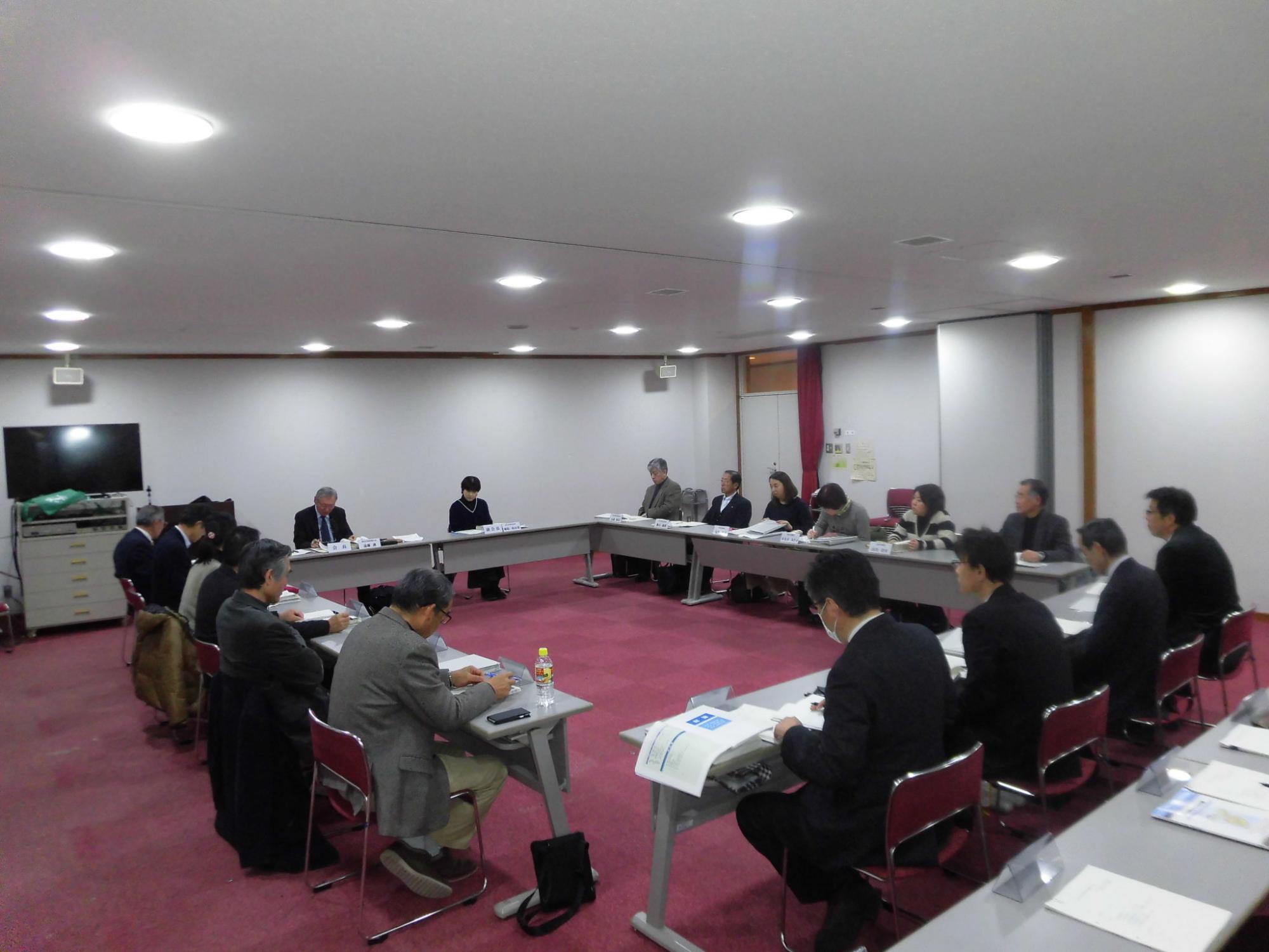 内側に向かい合うように長方形に並べられた席に座り、話し合いをしている第3回総合計画審議会の写真