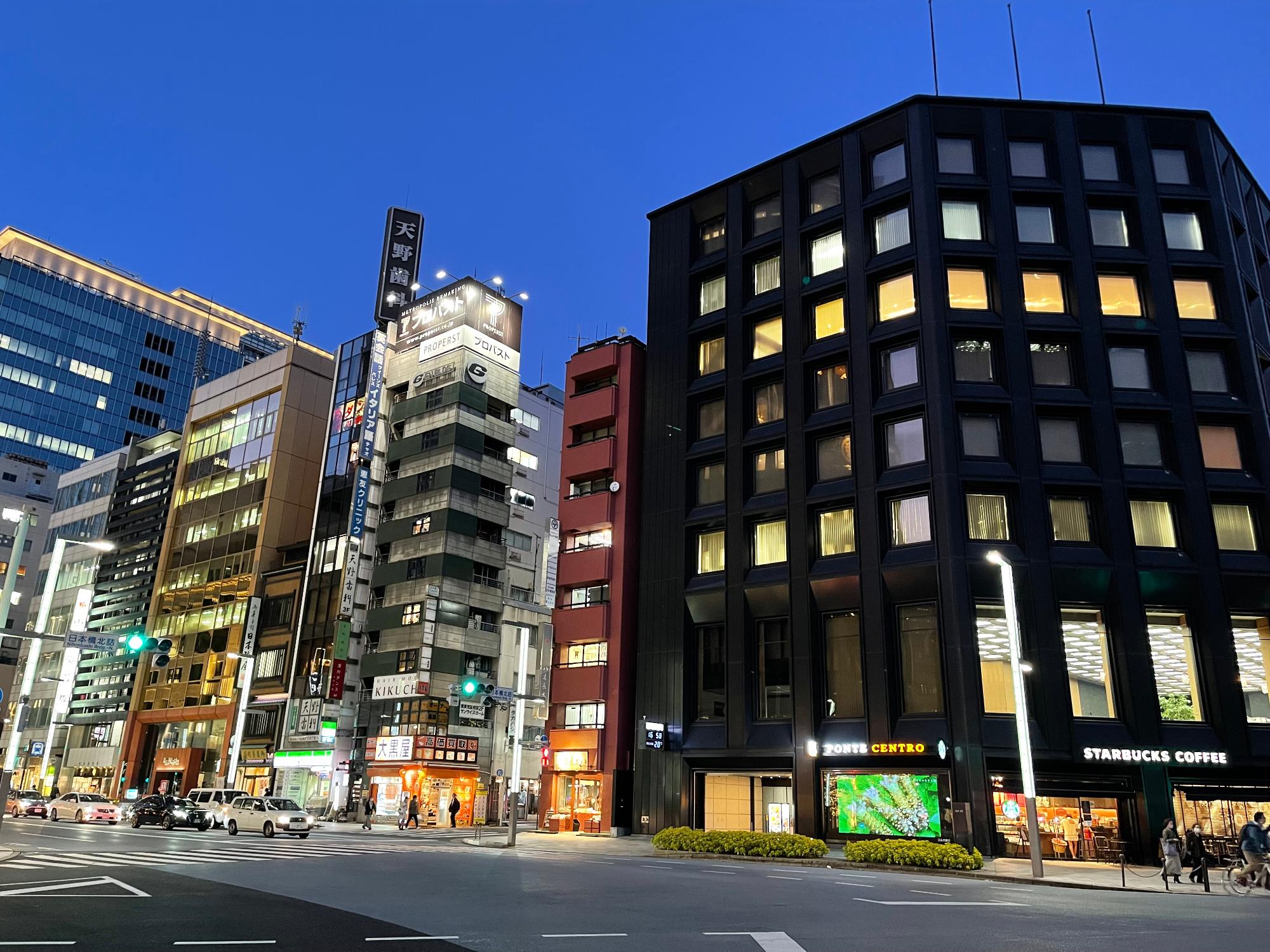 周りにビルが立ち並び、スルガ銀行屋外にルボードサイネージにふるさと納税返礼品のわさびが紹介されている映像の写真