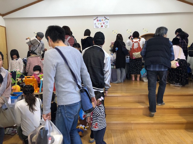 家族連れや多くの人々で賑わうフリーマーケット会場の写真