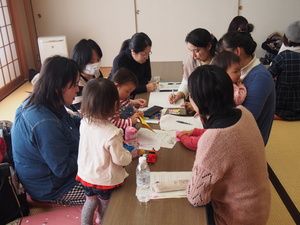 ママスタッフの方々が話し合いをする中、資料やメモを興味津々で見ている子どもたちの写真