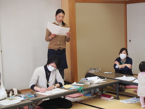 立ってメモを見ながら話し合いの内容を発表している女性の写真