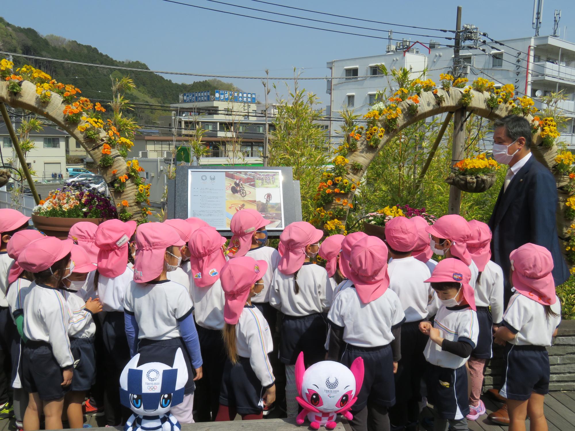花壇の前に設置されたレガシー銘板の周り集まる園児と市長の写真