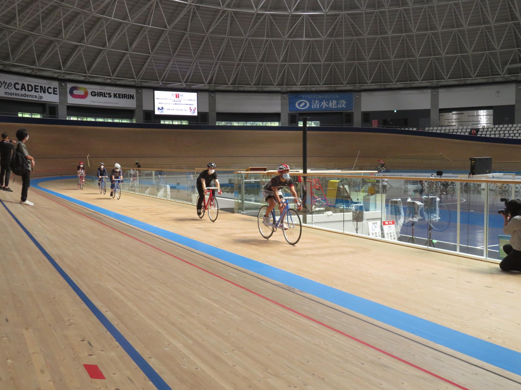 木製トラックで、実際に自転車に乗り試乗している参加者の写真