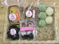 包装されたクッキーやまんじゅう、ケーキなどがかごの中に並べられている写真