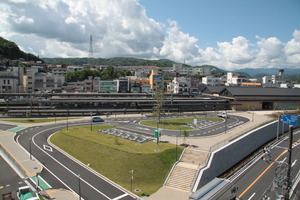 中央にある円形の芝生の周りをアスファルトの道路が囲んでいるロータリーの写真