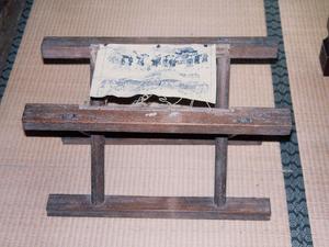 木製の看板の上に布のようなものが貼り付けられている写真