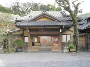 奥に畳の部屋と壁の模様が見える瓦の屋根と木造で造られた眠雲閣落合樓の玄関写真