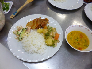 ごはん、サラダ、スープ、大根と豚肉の煮込み、野菜のチーズ煮込みがお皿に盛りつけられている写真