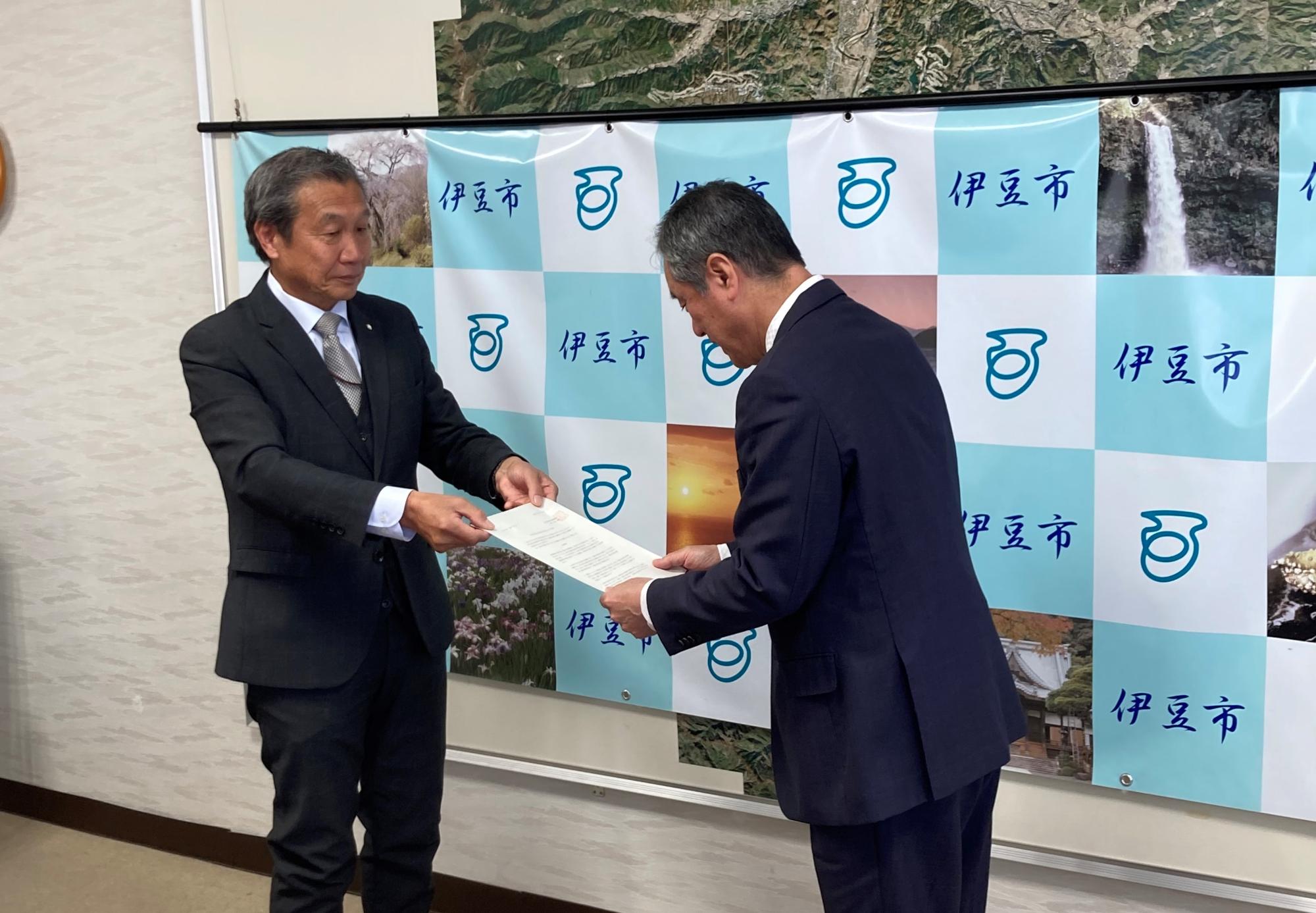 山田会長が市長に答申書を手渡している様子の写真