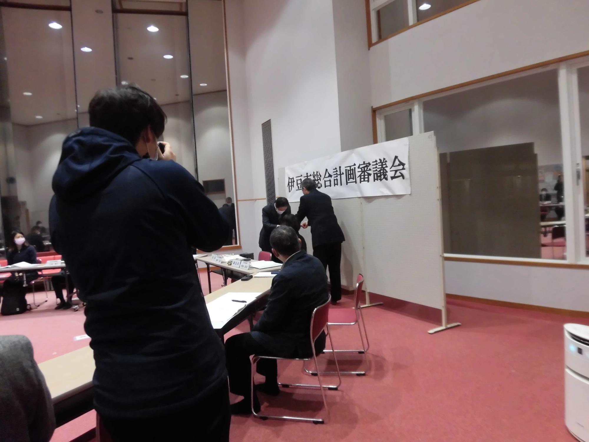 市長が飯田会長に諮問書を手渡しする様子を右側から撮影した写真
