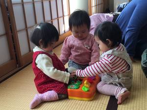 3人の子供たちが同じおもちゃで遊んでいる様子の写真