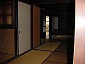 畳の和室と、左側に引き戸が開いた部屋が映る写真