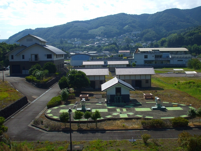 後ろに山々や建物がある、白岩浄化センターの外観写真