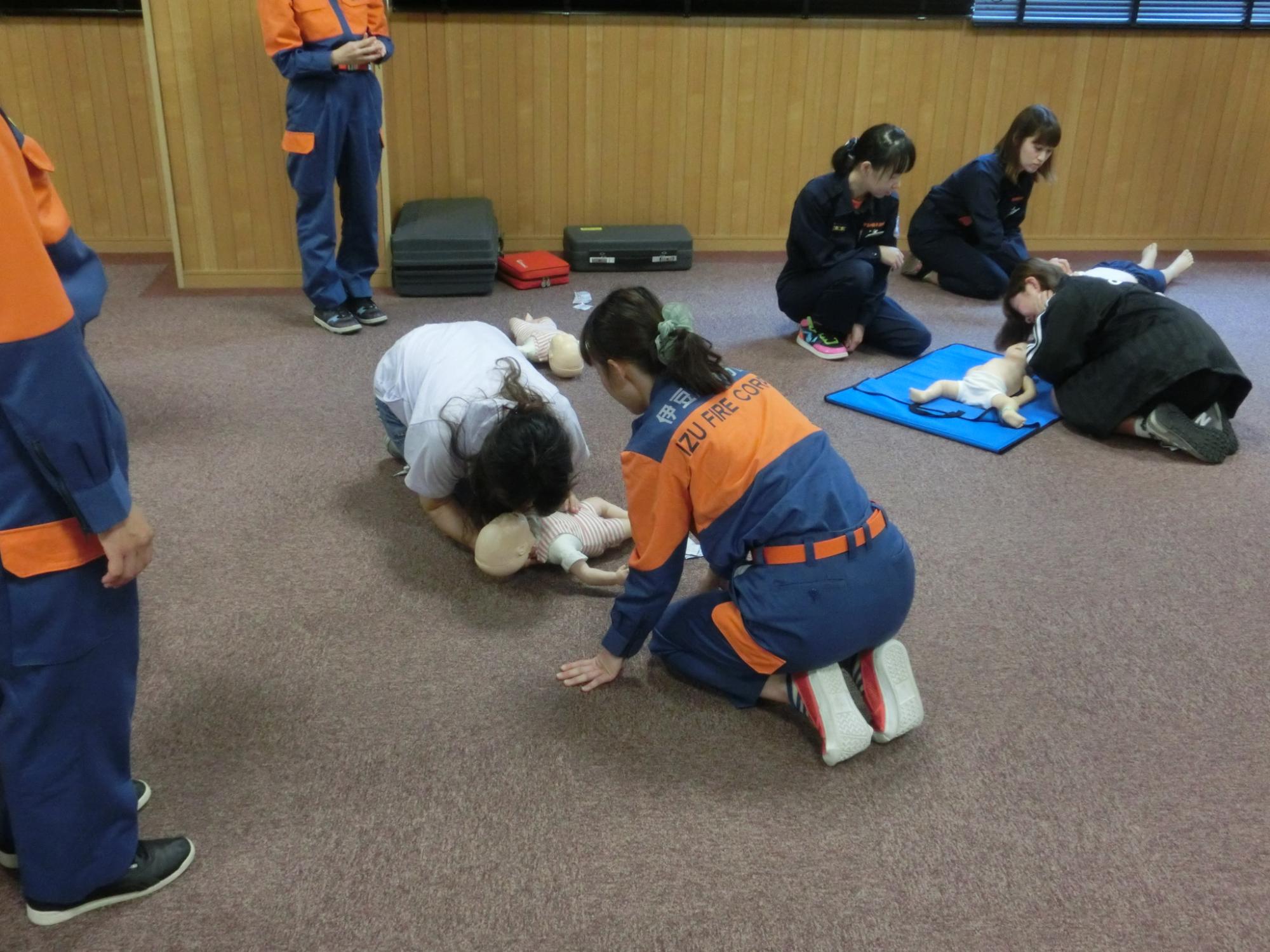 女性隊員が人形を使って救命の際の人工呼吸などの指導をしている様子の写真