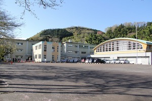 校庭の奥に体育館や2棟の校舎が見える天城小学校の写真