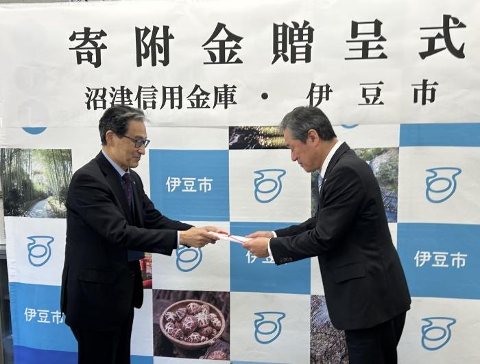 贈呈式の様子 鈴木理事長から菊地市長へ目録贈呈