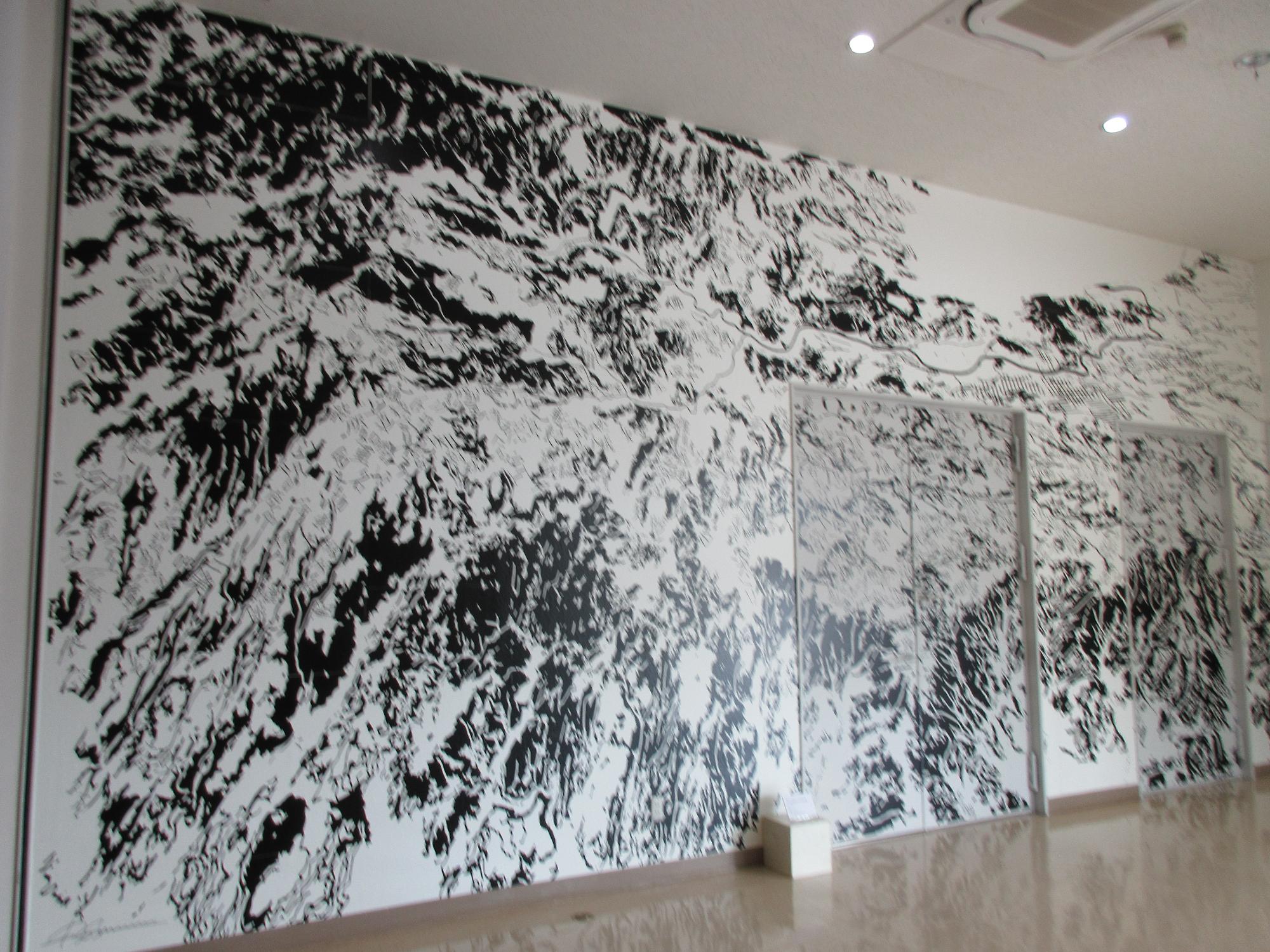 壁一面に白と黒で描かれた清水さんの作品「中伊豆俯瞰図―声字実相義（しょうじじっそうぎ）―」の写真