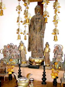 中央に大きな菩薩が立っていて、両脇に小さな菩薩や十二神将が数体飾られている写真