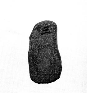楕円形で、上の方に漢字の三のような字が彫られている石の白黒写真