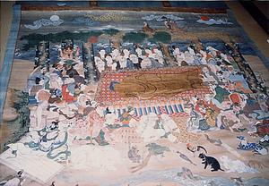 横たわった釈迦の周囲に弟子たちや動物が集まっている様子が描かれている絵画の写真