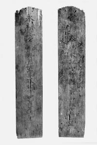 先の方がひび割れている細長い長方形の板に文字が書かれている柿木魂神社永禄三年の棟札の写真