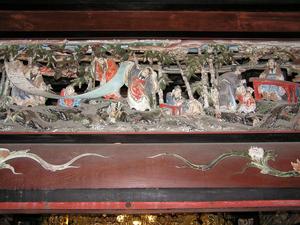 木で造られた枠の中に着物を着た人たちが彫られている實成寺祖師堂の彫刻の写真