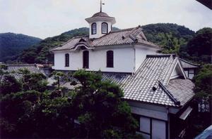 白い壁と瓦の屋根の頂上に六角の洋風塔屋がついている新井旅館青州楼他の建物の写真