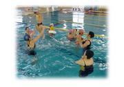水着姿の参加者がプールに入り練習をする教室の様子の写真