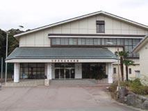 三角屋根で白の外壁の中伊豆社会体育館を正面入口から撮影した写真