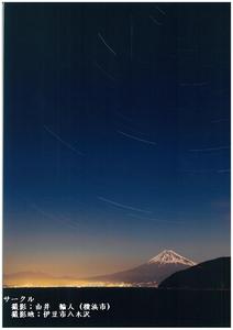 登る朝日が金色に輝き、山頂が雪をかぶった富士山を撮影した写真