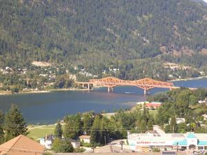 広い湖の岸から岸に架かるオレンジ色の橋の写真