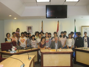 中央にネルソン市長が座りその後ろに生徒たちが並んで立っている集合写真