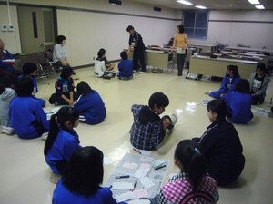 数人のグループに分かれて床に座り、発表の準備をしている子供たちの写真