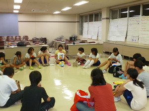 生徒たちが円になって座り想い出の品などをもって感想を発表している様子の写真