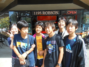 「1195 ROBSON」と書かれたお店の前に立つ生徒たち4人と大人2人の写真