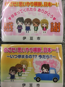 「めざせ!思いやり横断、日本一!!」のイラストが描かれた2種類のポケットティッシュの写真