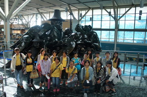 空港内のハイダ・グワイの精神の彫刻作品の前に並んでいる参加者や関係者の集合写真