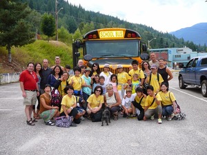 大きなスクールバスの前に集まった参加者達とホストファミリーの集合写真